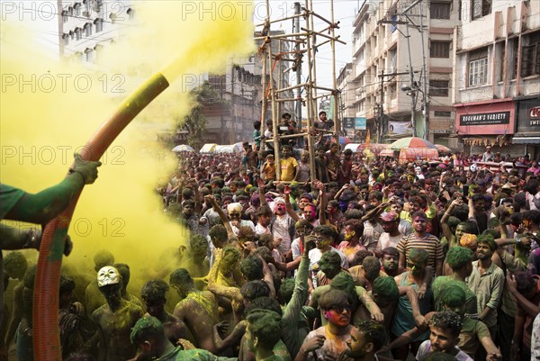 Revellers dancing in the beat of music as they celebrate Holi on a street, the Hindu spring