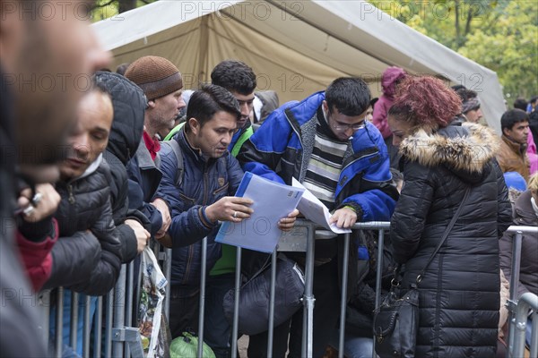 Refugees from Syria wait behind barriers in the Central Reception Centre for Asylum Seekers at the