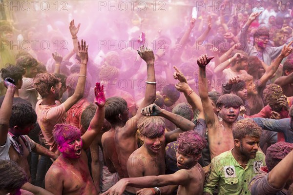 Revellers dancing in the beat of music as they celebrate Holi on a street, the Hindu spring