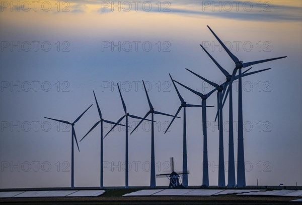 Windmill Poldermolen De Goliath stands between the high-tech wind turbines in Eemshaven, historic