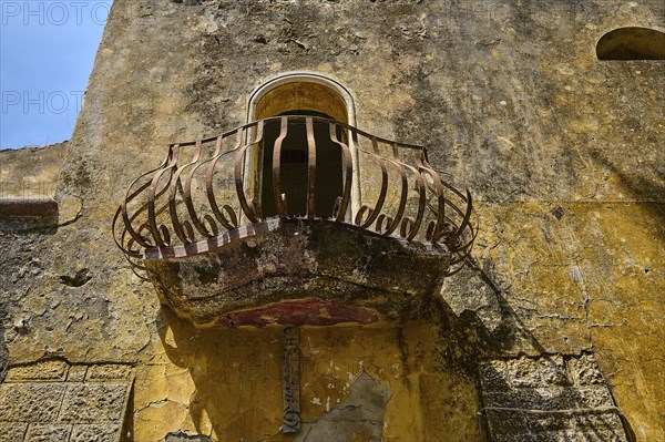 An abandoned balcony with a rusty railing on an old, weathered wall, Italian Governor's Palace,