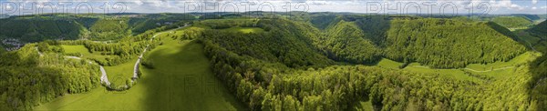 Winding country road through a forest, landscape of the Swabian Alb in spring, panoramic photo,