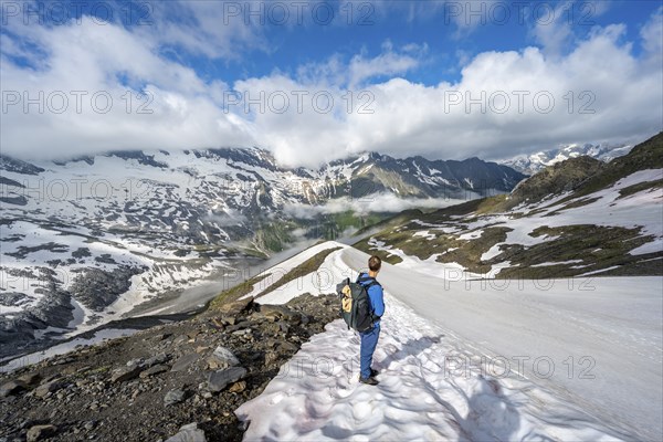 Mountaineer on hiking trail with snow, mountain landscape with summit Hoher WeiÃŸzint and