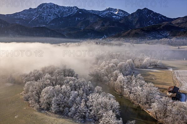 Aerial view of a river in front of mountains in winter, hoarfrost, fog, morning light, view of
