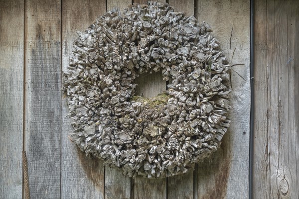 Door wreath made of natural materials in front of a wooden wall, Münsterland, North