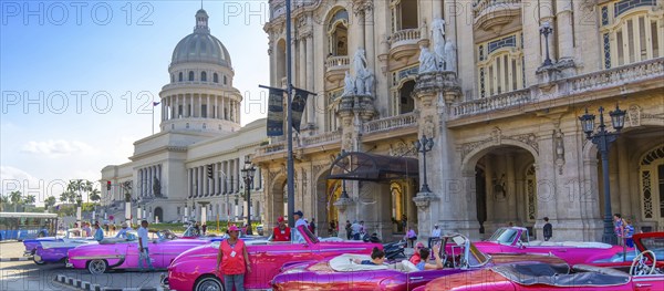 Havana, Cuba â€“ 16 December, 2019: Vintage colorful taxis waiting for tourists close to National