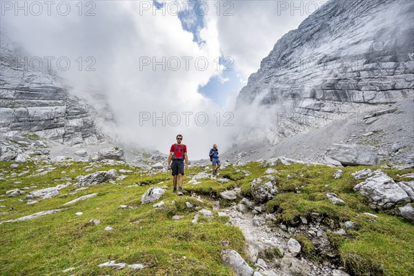 Two mountaineers on a hiking trail, cloudy mountain basin, descent via the Ofental valley, mountain