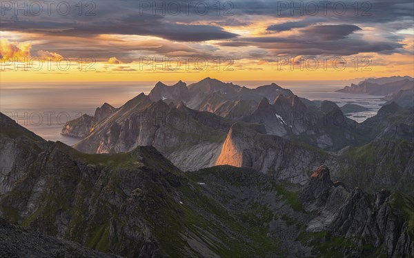 View over mountain top and sea, dramatic sunset, from the top of Hermannsdalstinden, Moskenesöy,