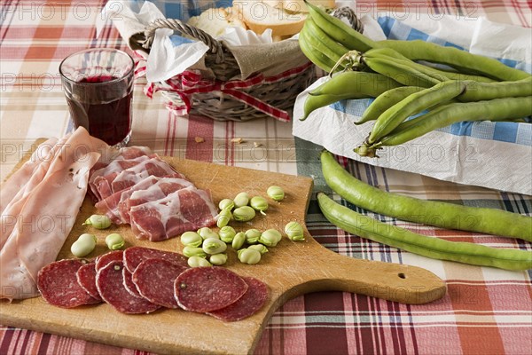 Trattoria table with cold meats broad bean and red wine