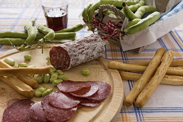 Italian salami broad bean and bread sticks over a chopping board