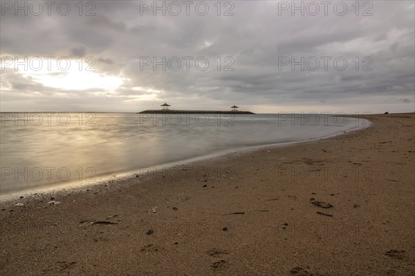 Beautiful seascape in the morning. Tropical sandy beach with breakwater and reflection of the sky