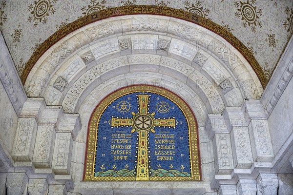 Cross mosaic in the tympanum with the quotation Eine feste Burg ist unser Glauben by Martin Luther,