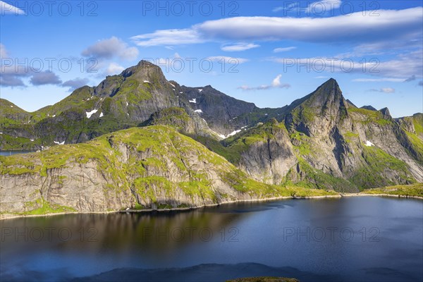 Mountain landscape with lake Tennesvatnet, at sunrise, in the back peak of Hermannsdalstinden,