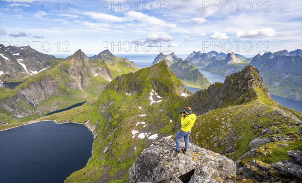 Mountaineer photographed at the summit of Munken, mountain landscape with steep rocky mountain
