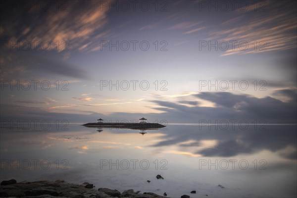 Beautiful seascape in the morning. Tropical sandy beach with breakwater and reflection of the sky