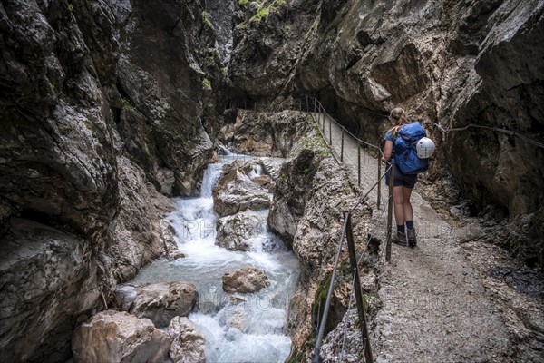 Hiker in a gorge, Hammersbach flows through Höllentalklamm, near Garmisch-Partenkirchen,