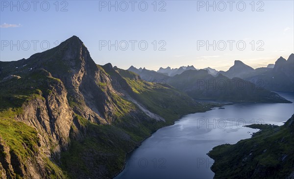Mountain landscape with pointed mountain peaks and fjord Forsfjorden with village Vindstad, at