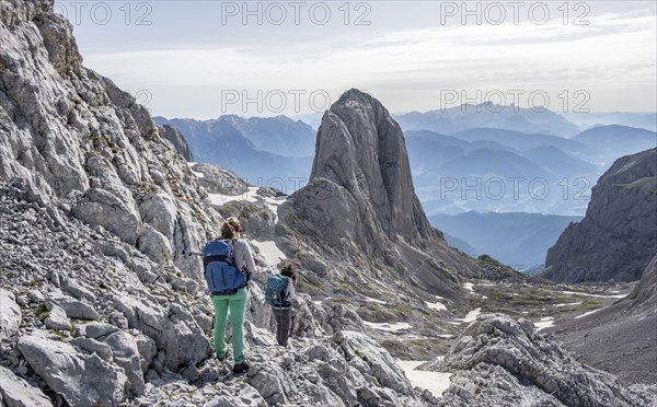 High alpine landscape, snowfields and rock, Two hikers descending from the Hochkönig, Tyrol,