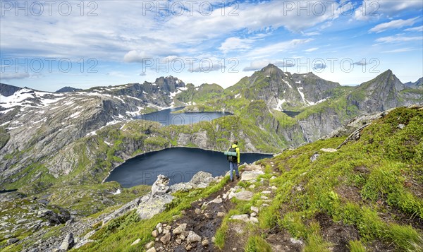 Mountaineers on a hiking trail, mountain landscape with steep rocky mountain peaks and lake