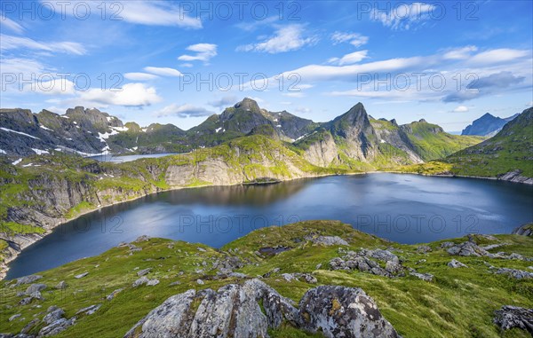 Mountain landscape with lake Tennesvatnet, at sunrise, in the back peak of Hermannsdalstinden,
