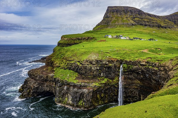 Gasadalur waterfall into the ocean, Vagar, Faroe islands, Denmark, Europe
