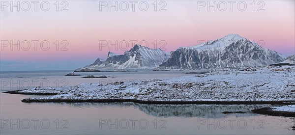 Ramberg with the mountains Hustinden and Bjorntinden in the background in winter dusk
