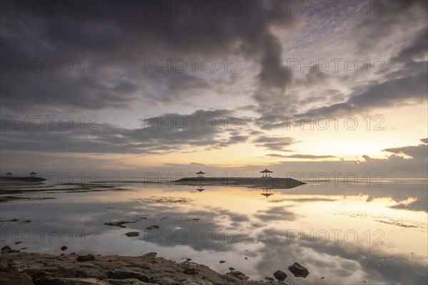 Beautiful seascape in the morning. Tropical sandy beach with breakwater and reflection of the sky