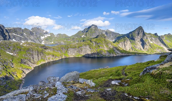 Mountain landscape with lake Tennesvatnet, at sunrise, in the back peak of Hermannsdalstinden,