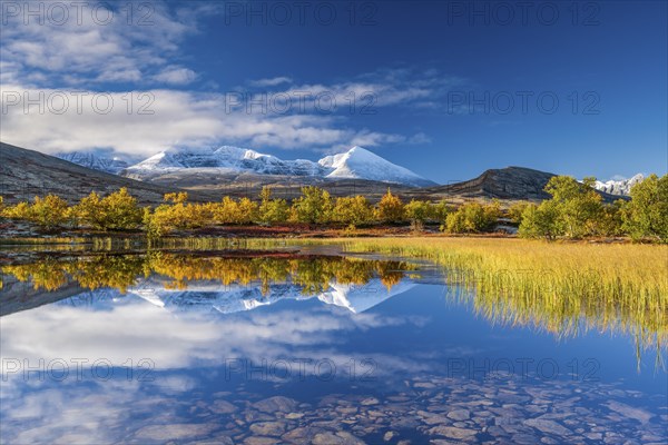 Reflection of the autumn landscape in Rondane National Park, snow-capped mountains, Doraldalen,