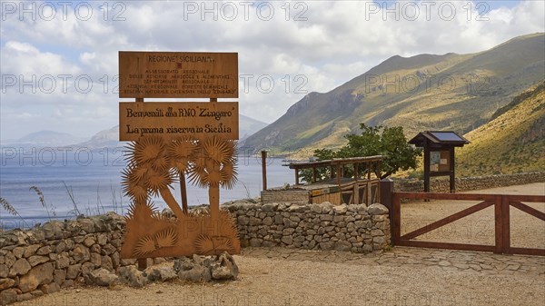 Welcome sign, stone wall, green mountains, cloudy sky, Zingaro, national park, nature reserve,