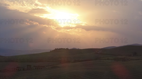 Evening backlight, bare hilly landscape, cloudy sky, single trees, Madonie National Park, autumn,