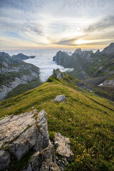 View over Säntis mountains into the valley of Meglisalp at sunrise, Rotsteinpass, high fog in the