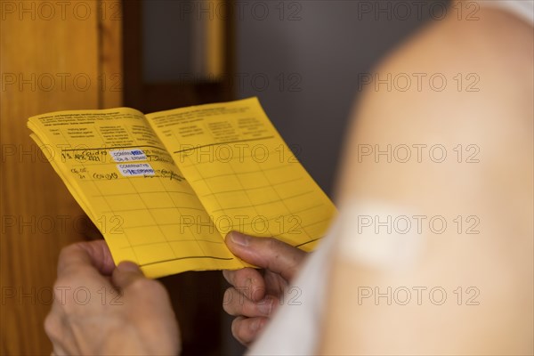 Woman vaccinated with a corona agent looks at her vaccination card