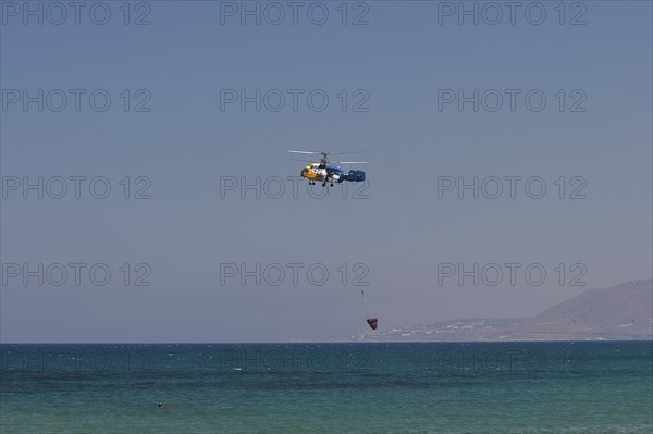 Helicopter, helicopter, fire-fighting helicopter, fire, helicopter close above the water surface,