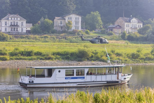 A Bundeswehr helicopter lands on the Elbe meadows in Bad Schandau on the Elbe, after a day of