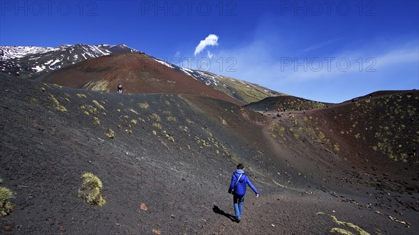 Lone visitor in crater, black lava field, red lava hill, Crateri Silvestri, Etna, volcano, Eastern