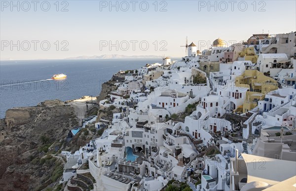 Cliff-side houses, villas and windmill in the village of Oia, Ia, as seen from the Kasteli Castle,