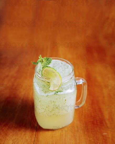 Refreshing lemonade with mint on wooden table. Lemonade drink on wooden background