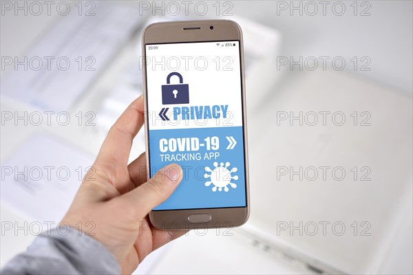 Corona Virus Tracking App privacy concerns concept with hand holding cell phone with application