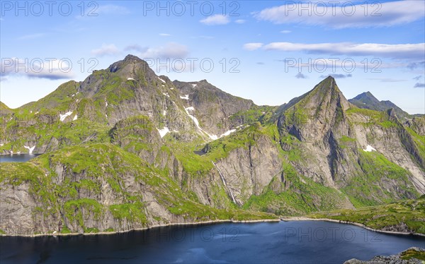 Mountain landscape with lake Tennesvatnet and steep rocky mountain peak with waterfall, peak of