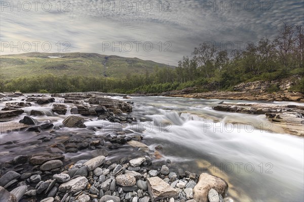 Abiskojakka, river in Abisko NP (northern Sweden) . Long exposure, clouds, rocks, forest