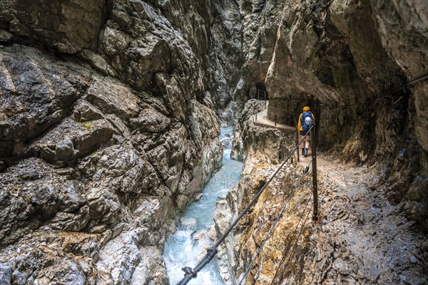 Hiker in a gorge, Hammersbach flows through Höllentalklamm, near Garmisch-Partenkirchen,