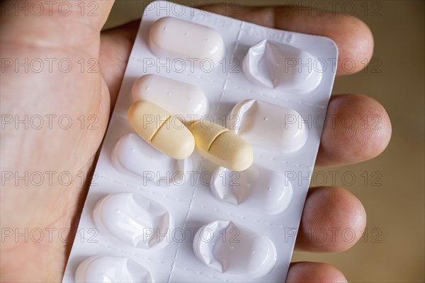Hand holding a blister pack with tablets
