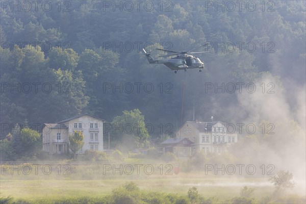 A Bundeswehr helicopter lands on the Elbe meadows in Bad Schandau on the Elbe, after a day of