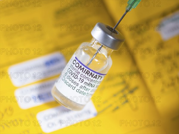 Symbolic image Corona vaccine Comirnaty in front of a vaccination certificate