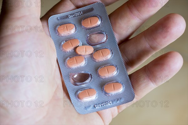 Hand holding a blister pack with tablets