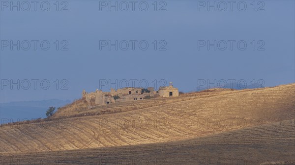 Dry hilly landscape, fields, farmstead, building, blue cloudy sky, Madonie National Park, autumn,