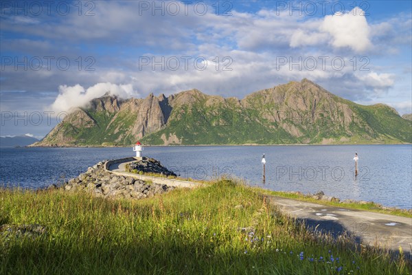 Lighthouse at harbour wall, fishing village Hovden, island Langoya, archipelago Vesteralen, Norway,