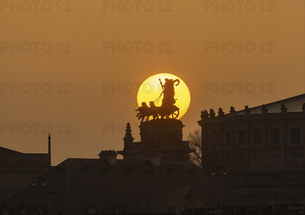 Sunset in Dresden. The sun's disc, particularly orange due to the Sahara dust, sets behind the