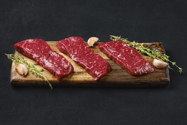 Raw strip steak boneless on wooden cutting board